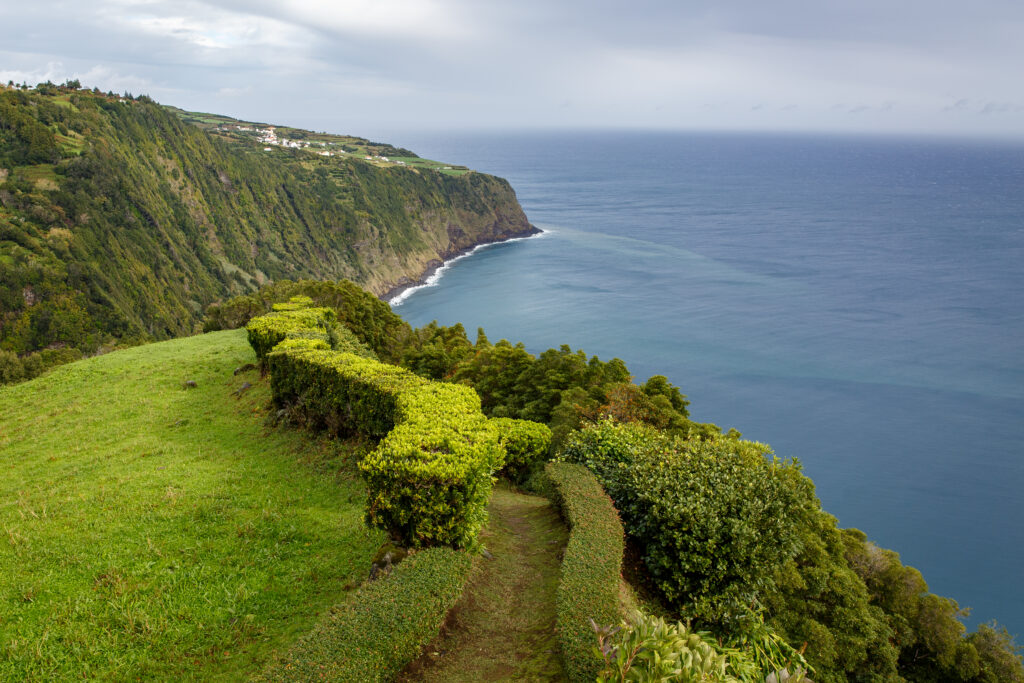 Meadows near ocean. San Miguel, Azores. Walking trail along the sea.